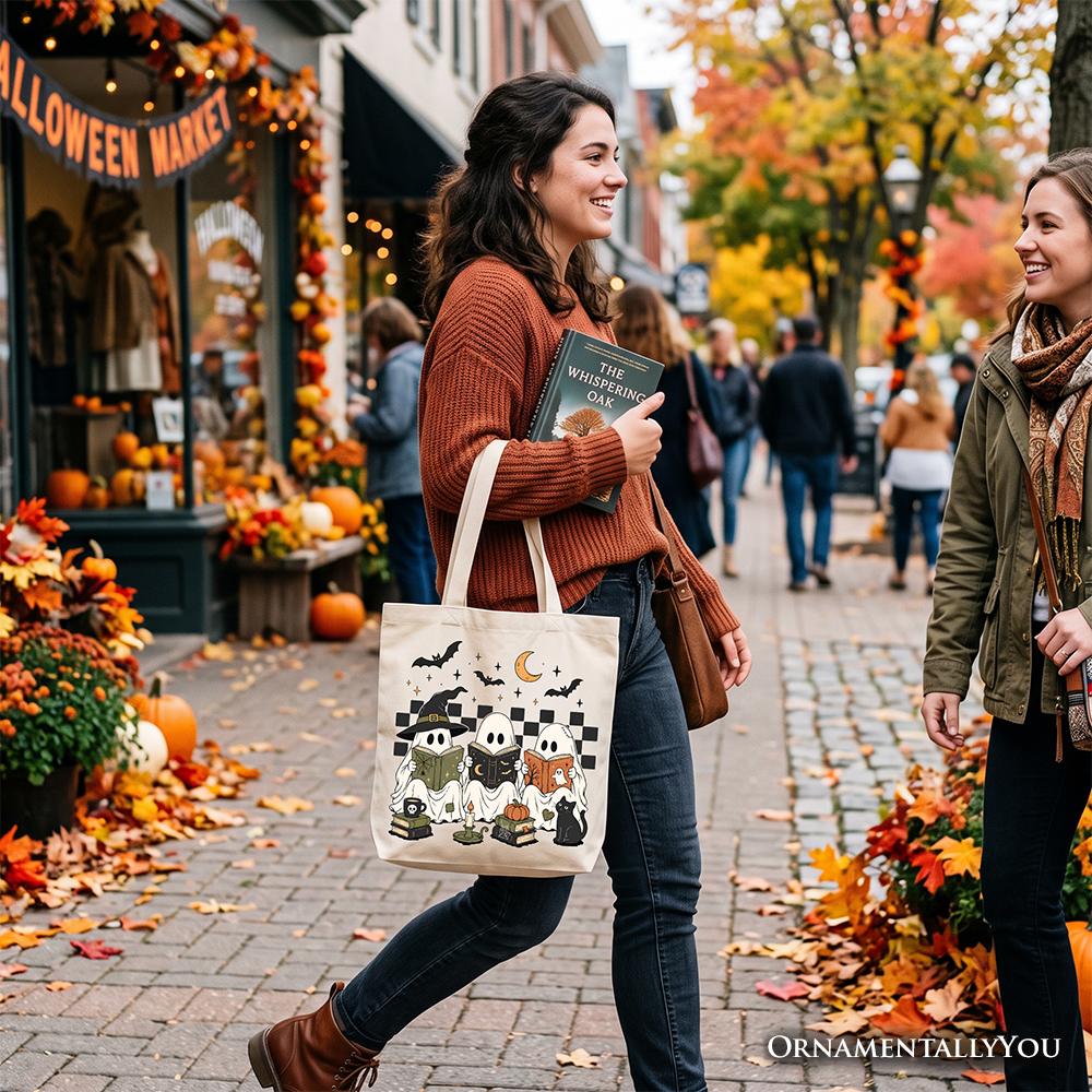 Black-printed Halloween tote bag hanging at side, worn on shoulder with two handles