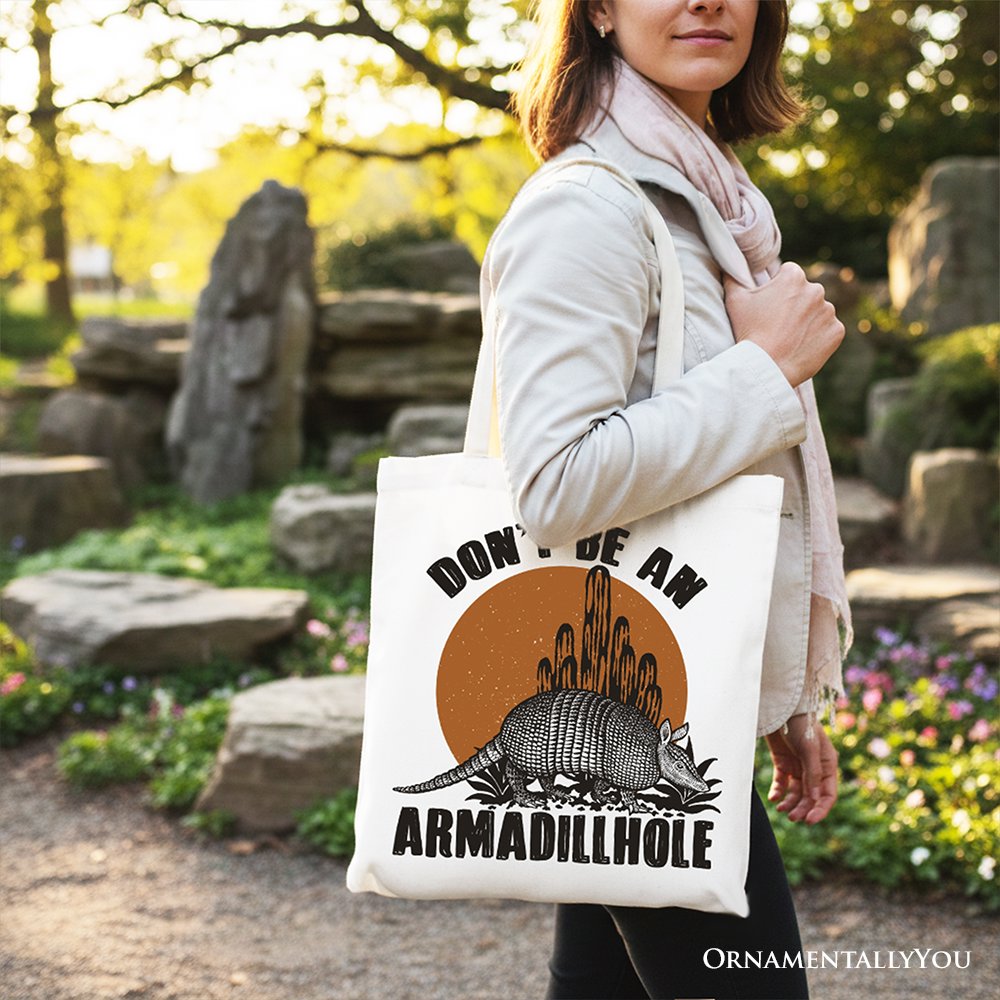 White canvas tote bag on shoulder with armadillohole graphic