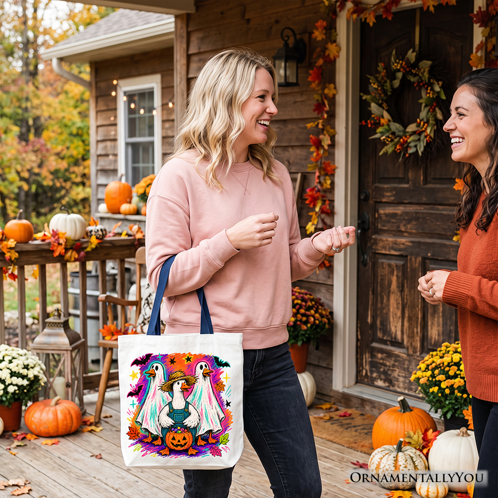 White tote bag featuring colorful goose family graphic and teal pumpkin detail.