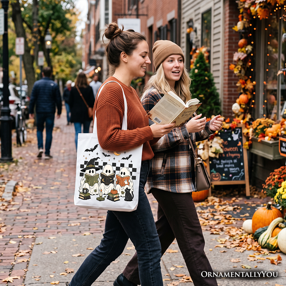 White tote bag with Halloween ghost and witch cat graphic, carried outdoors