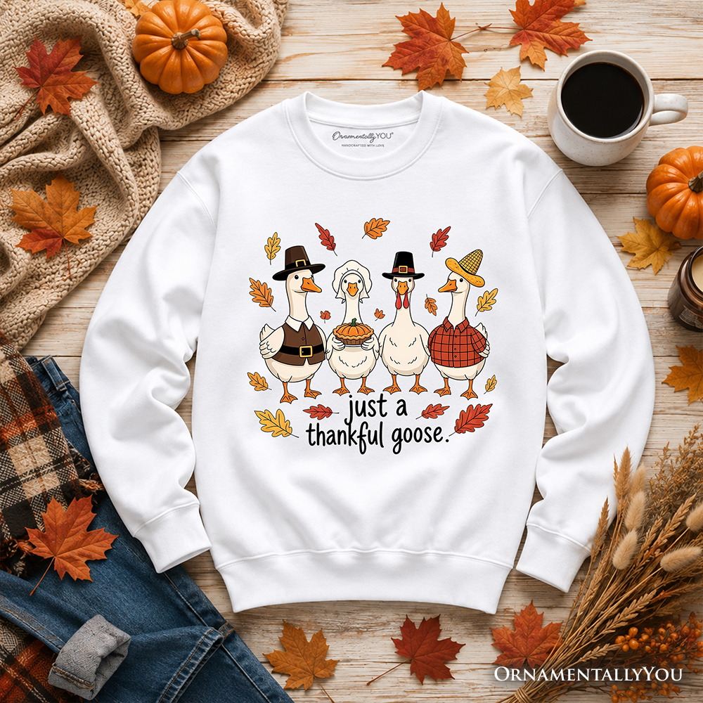 White sweatshirt with cartoon turkey trio and text 'just a thankful goose' on front