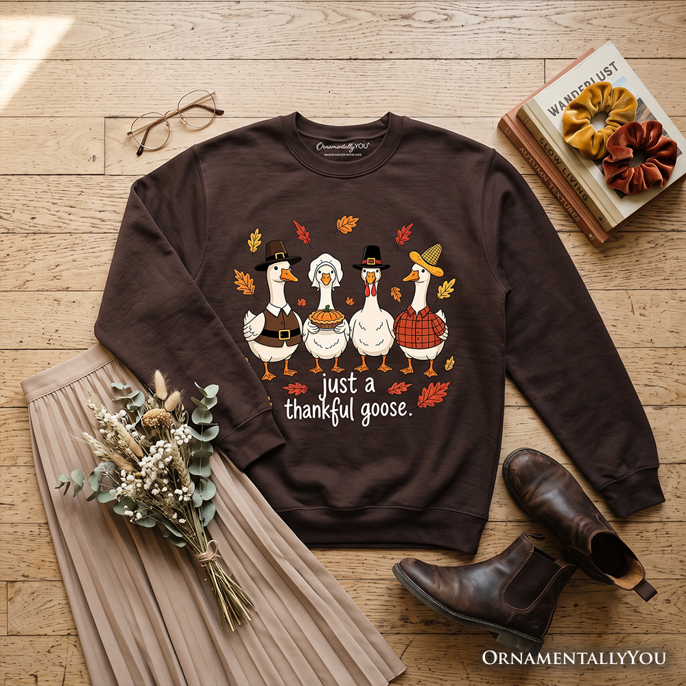 Dark brown crewneck sweatshirt laid flat with geese graphic and "just a thankful goose" text