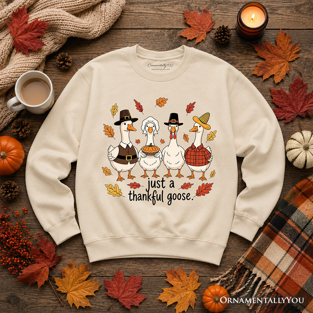 Cream crewneck sweatshirt laid flat with geese graphic and "just a thankful goose" text
