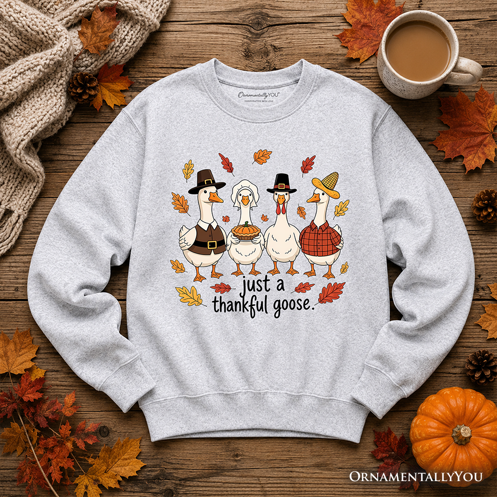Light gray crewneck sweatshirt laid flat with geese graphic and "just a thankful goose" text