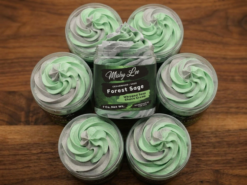 Five small jars of green whipped soap and shave cream arranged on a wood table