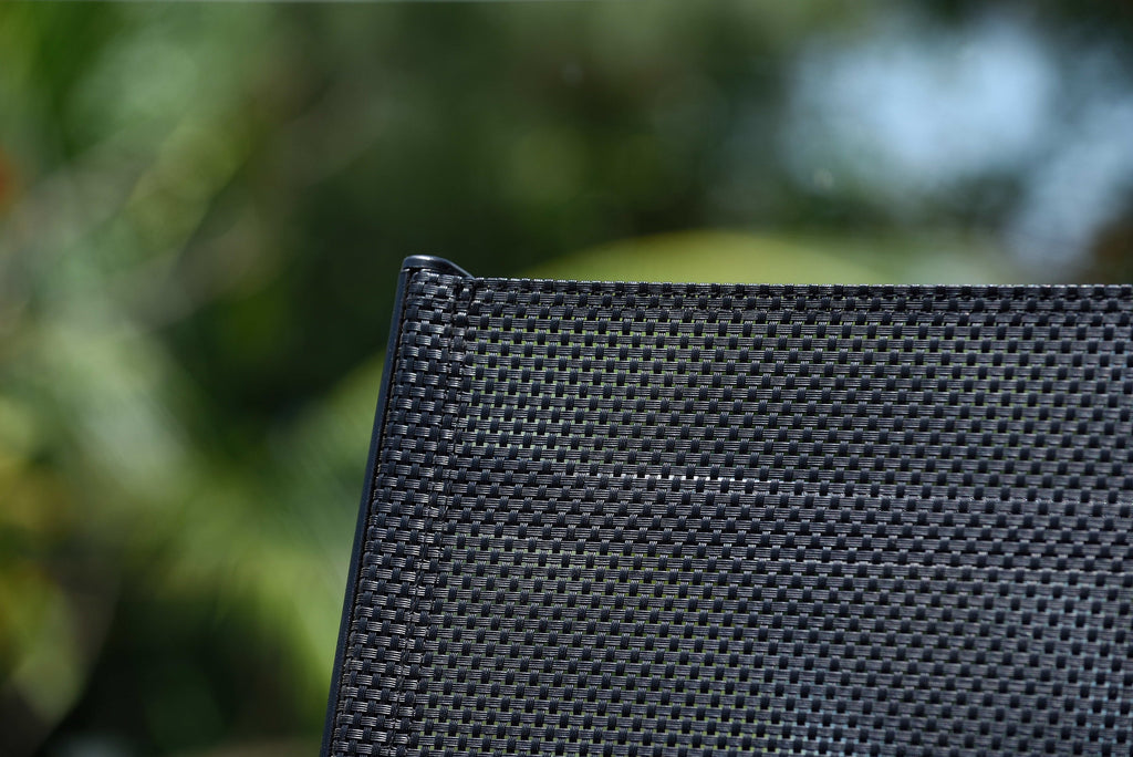 Close-up of black mesh backrest on teak outdoor armchair