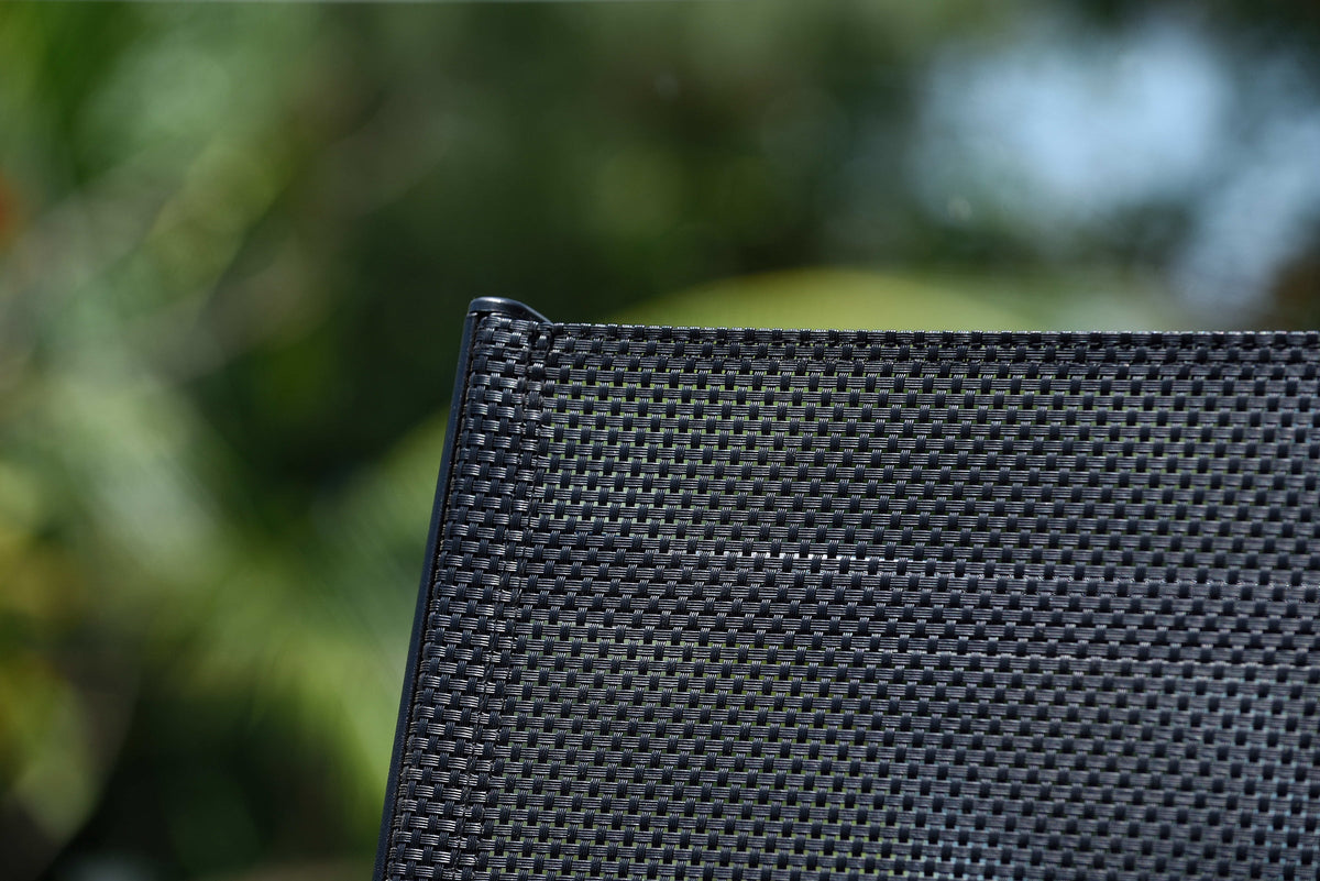 Close-up of black mesh backrest on teak outdoor armchair