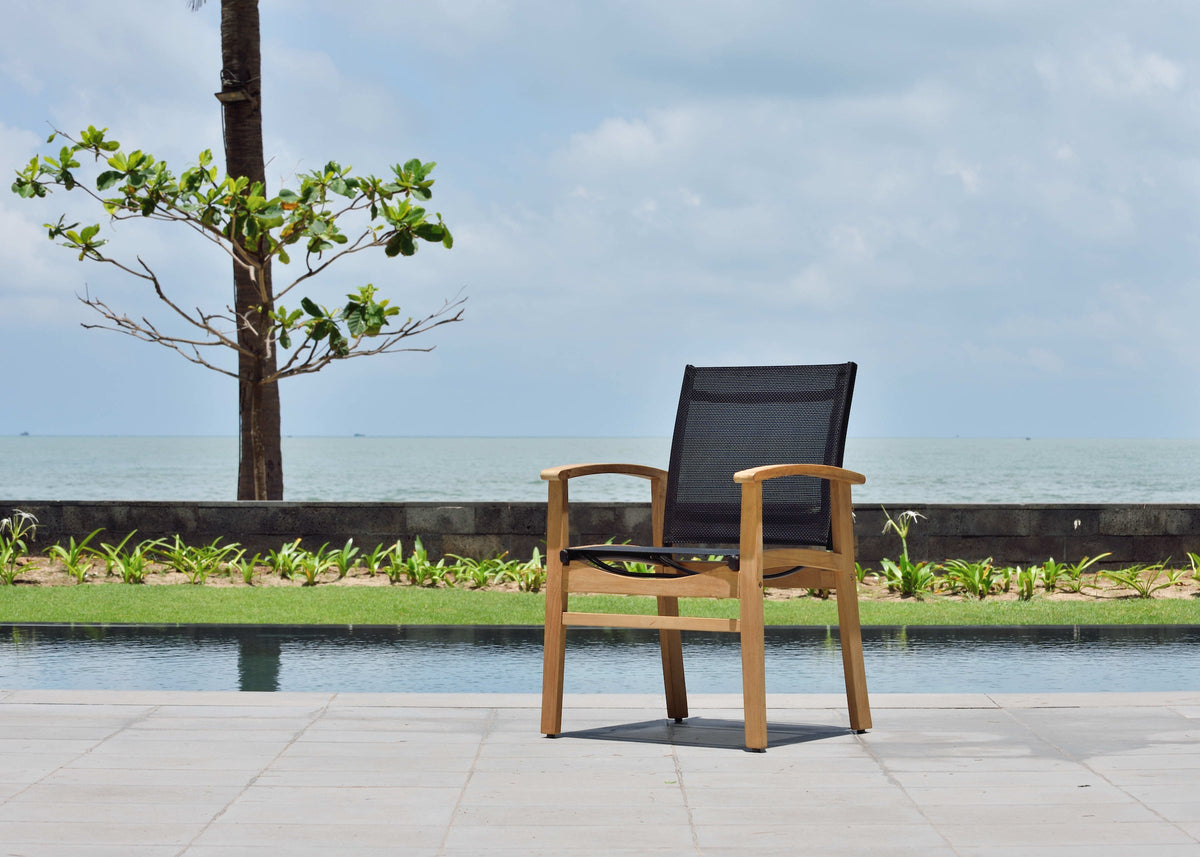 Single outdoor armchair with light teak arms and black mesh back near pool