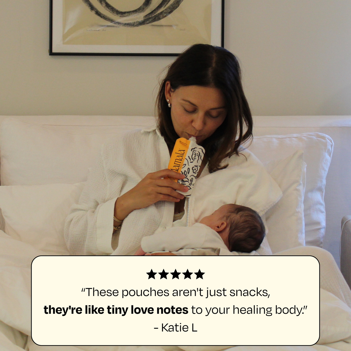 Woman holding a snack-style supplement pouch while breastfeeding in bed.