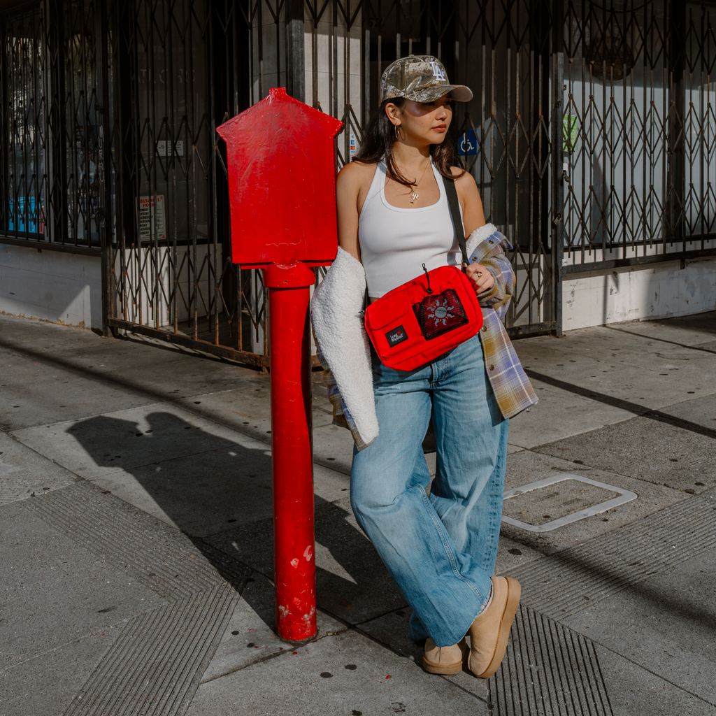 Red crossbody shoulder bag with adjustable strap and zip front pocket.