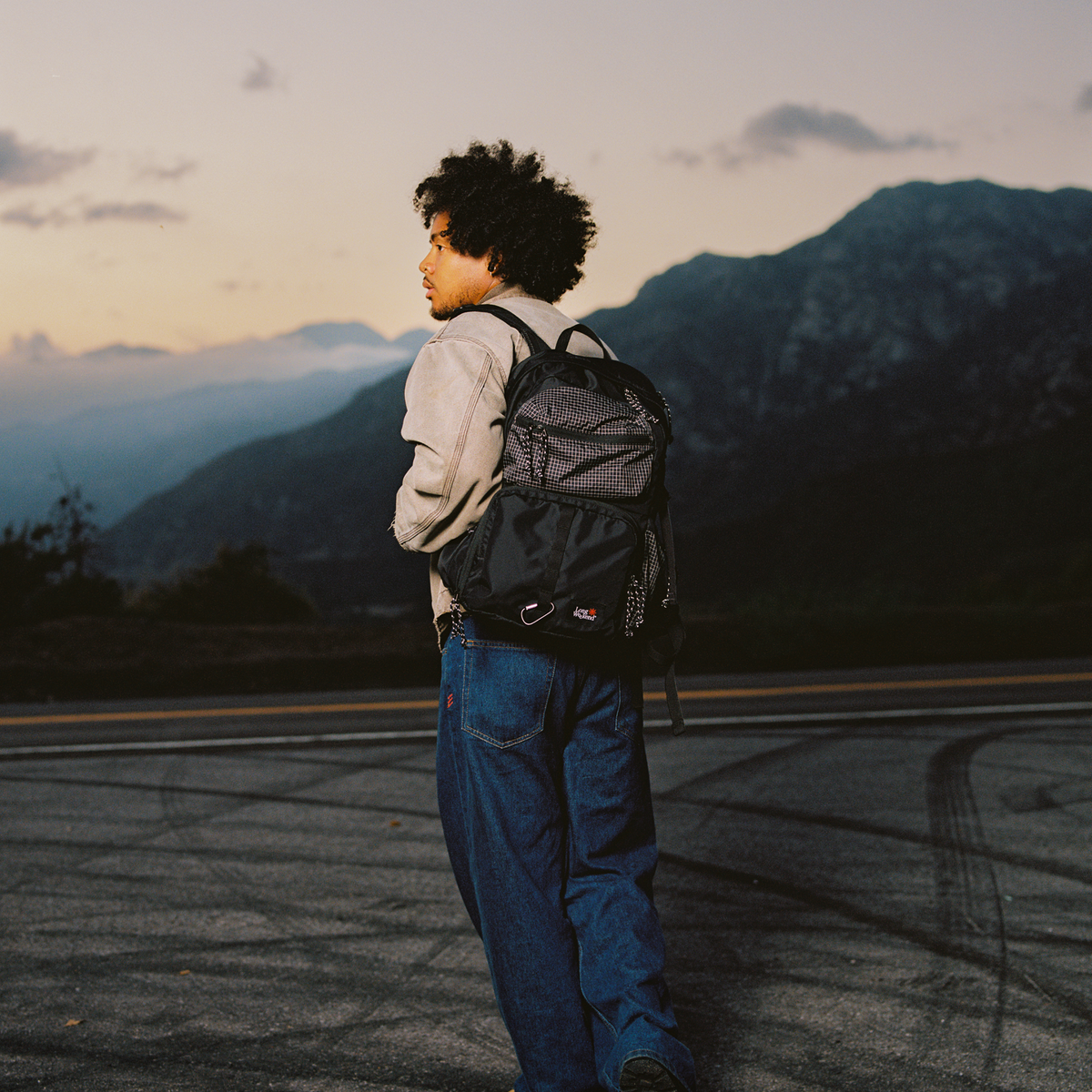 Black convertible backpack worn by a person, rear side view