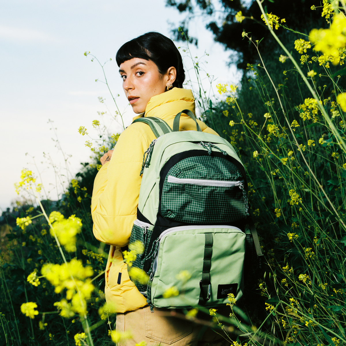 Moss green convertible backpack worn by a person, side view