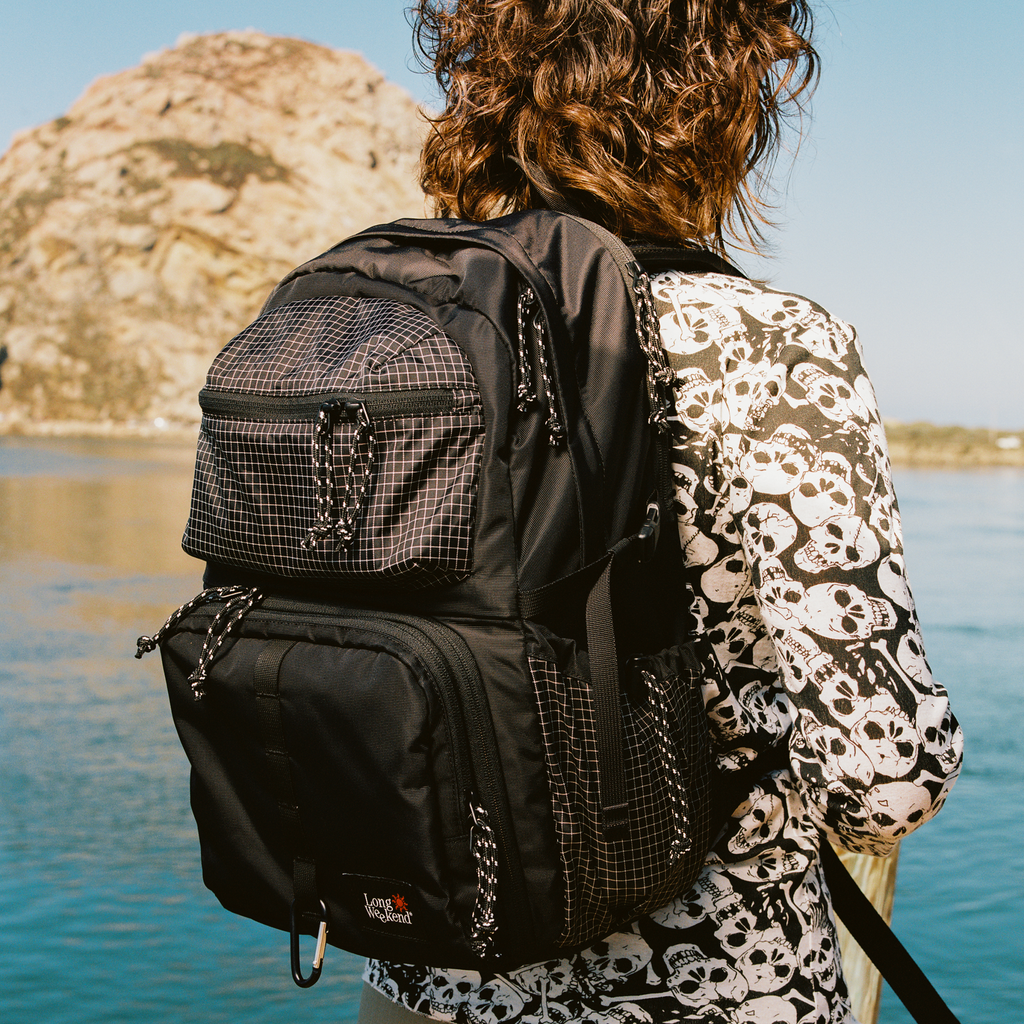 Black convertible backpack with front zip pocket and mesh panel detail, adjustable straps