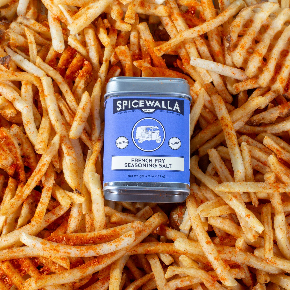 French fry seasoning salt tin nestled among fries covered in orange seasoning