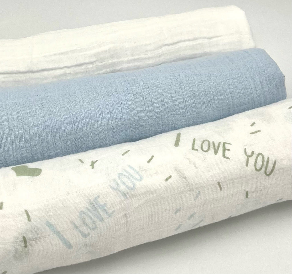 White fabric keepsake blanket with green “I love you” text and small accent shapes