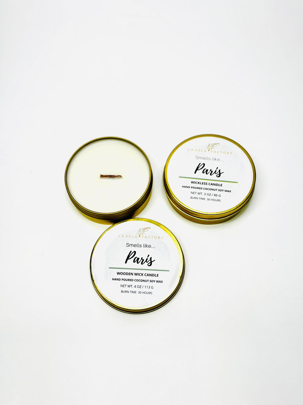 Wood-wick candle in gold tins; lids labeled Paris.