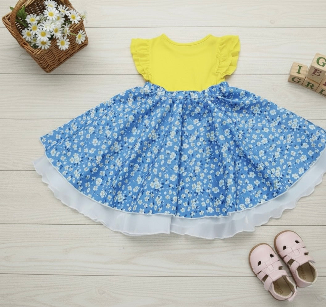 Toddler dress with yellow top and blue floral skirt, white ruffle trim at hem