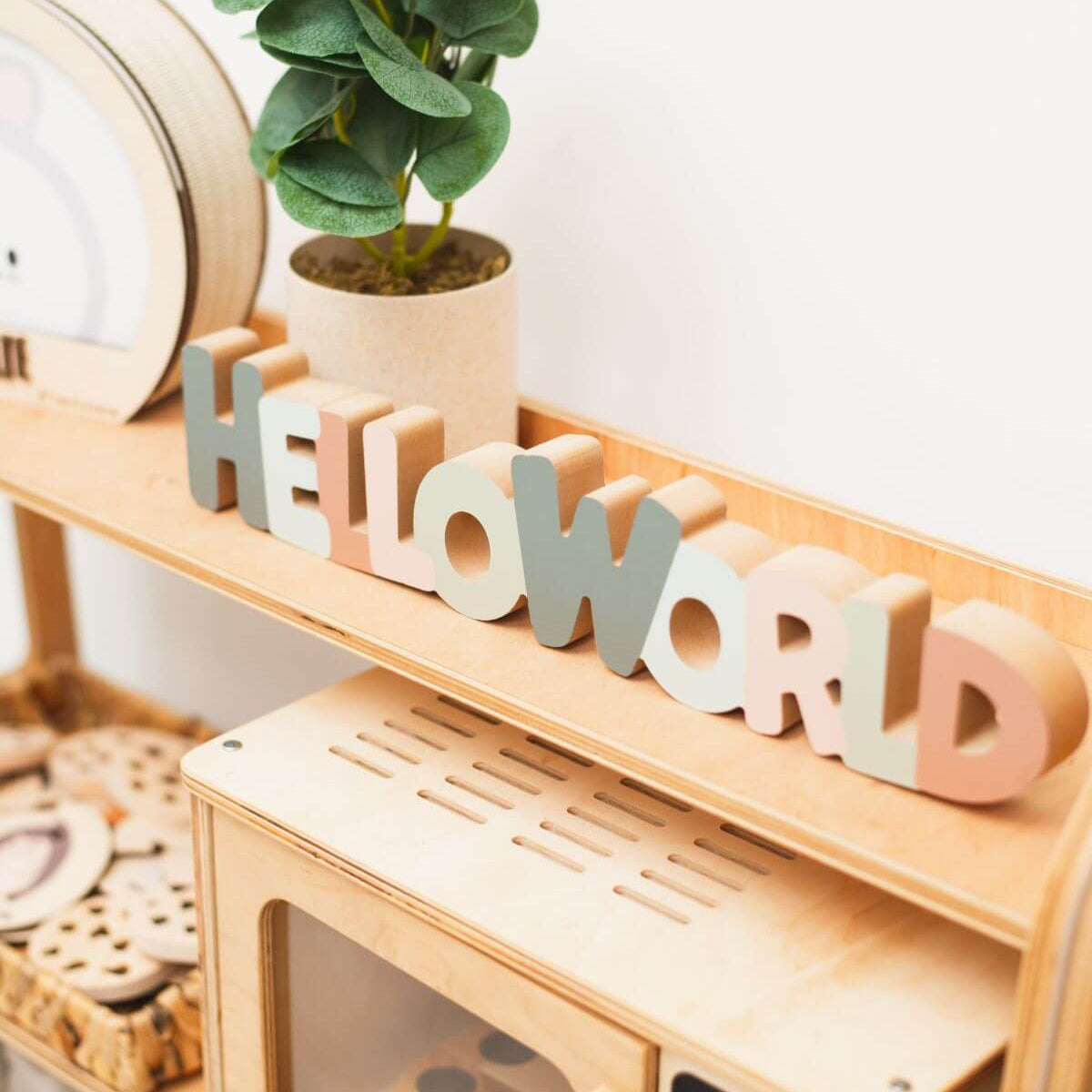 Close-up of light wood playroom organizer shelf with “H” letters and slatted panel