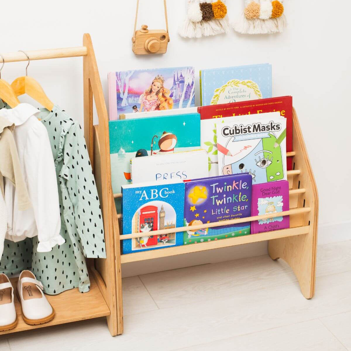 Light wood kids book and toy organizer with front bins and hanging garment hooks