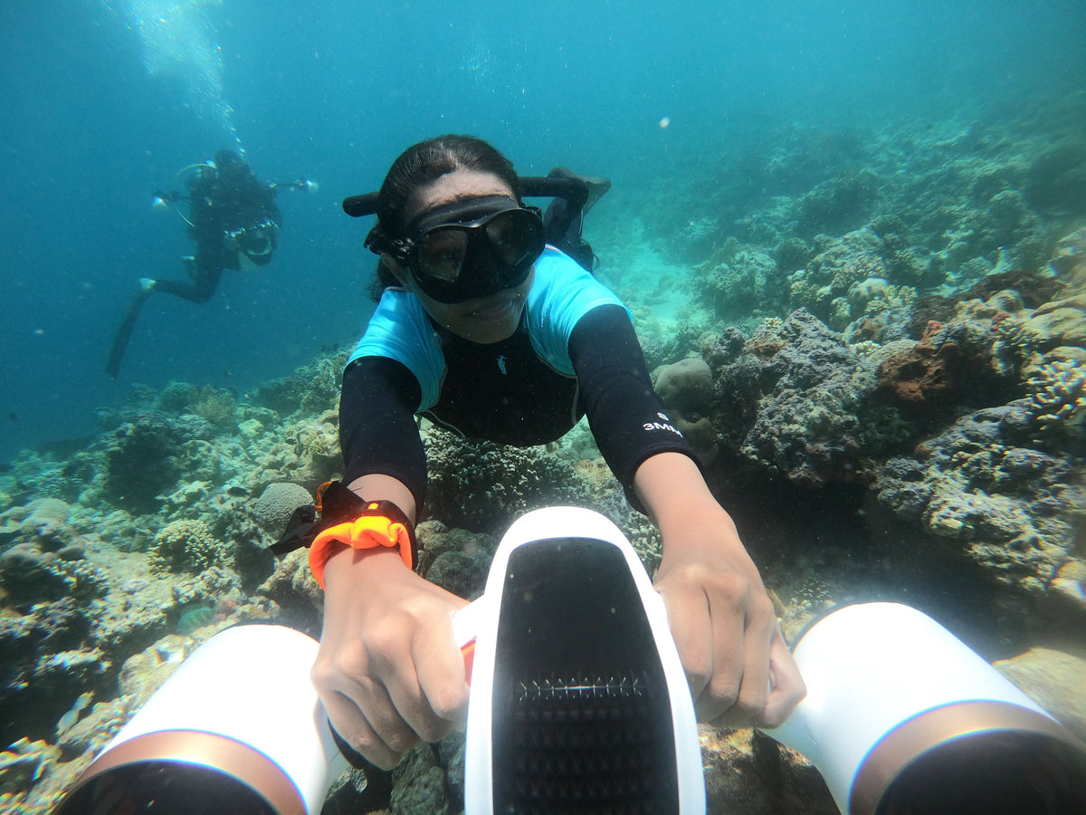 Underwater diver reaching toward camera unit with glowing orange light