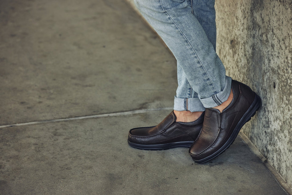 Dark brown leather slip-on loafer on foot with cushioned sole and side seam