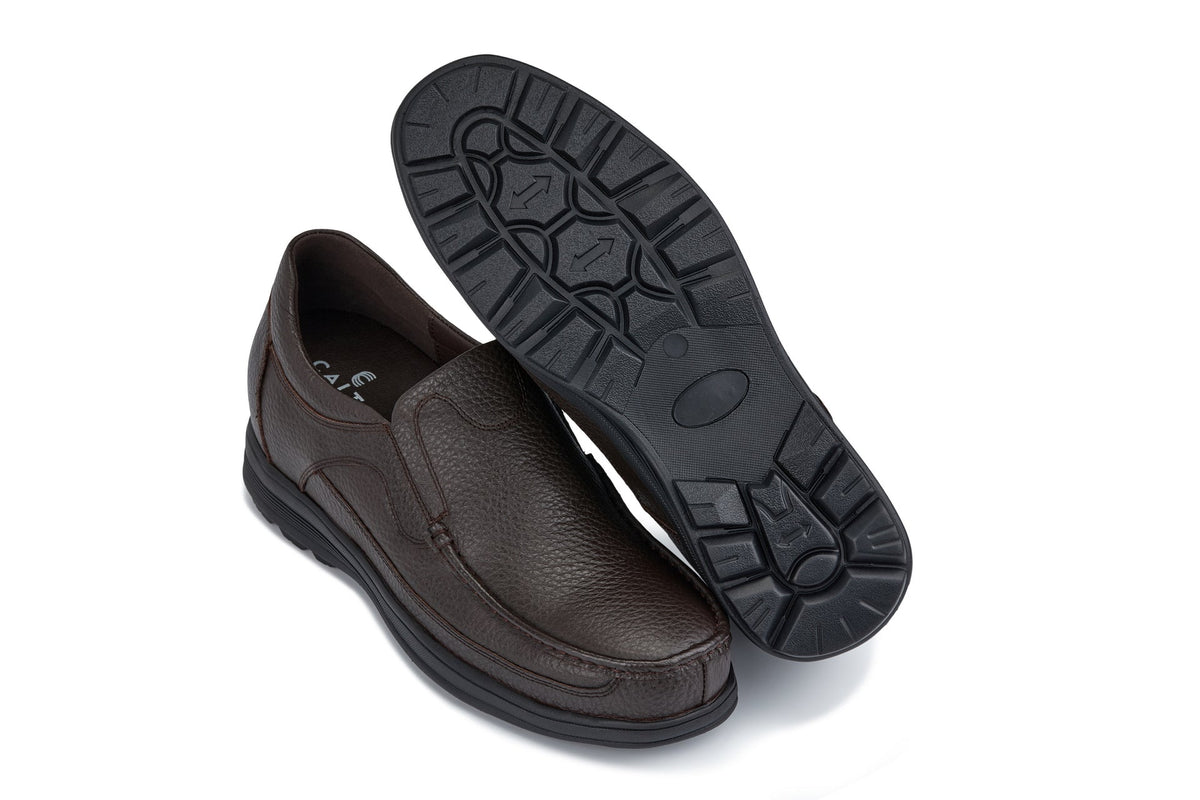 Dark brown slip-on loafer showing treaded rubber outsole and instep seam