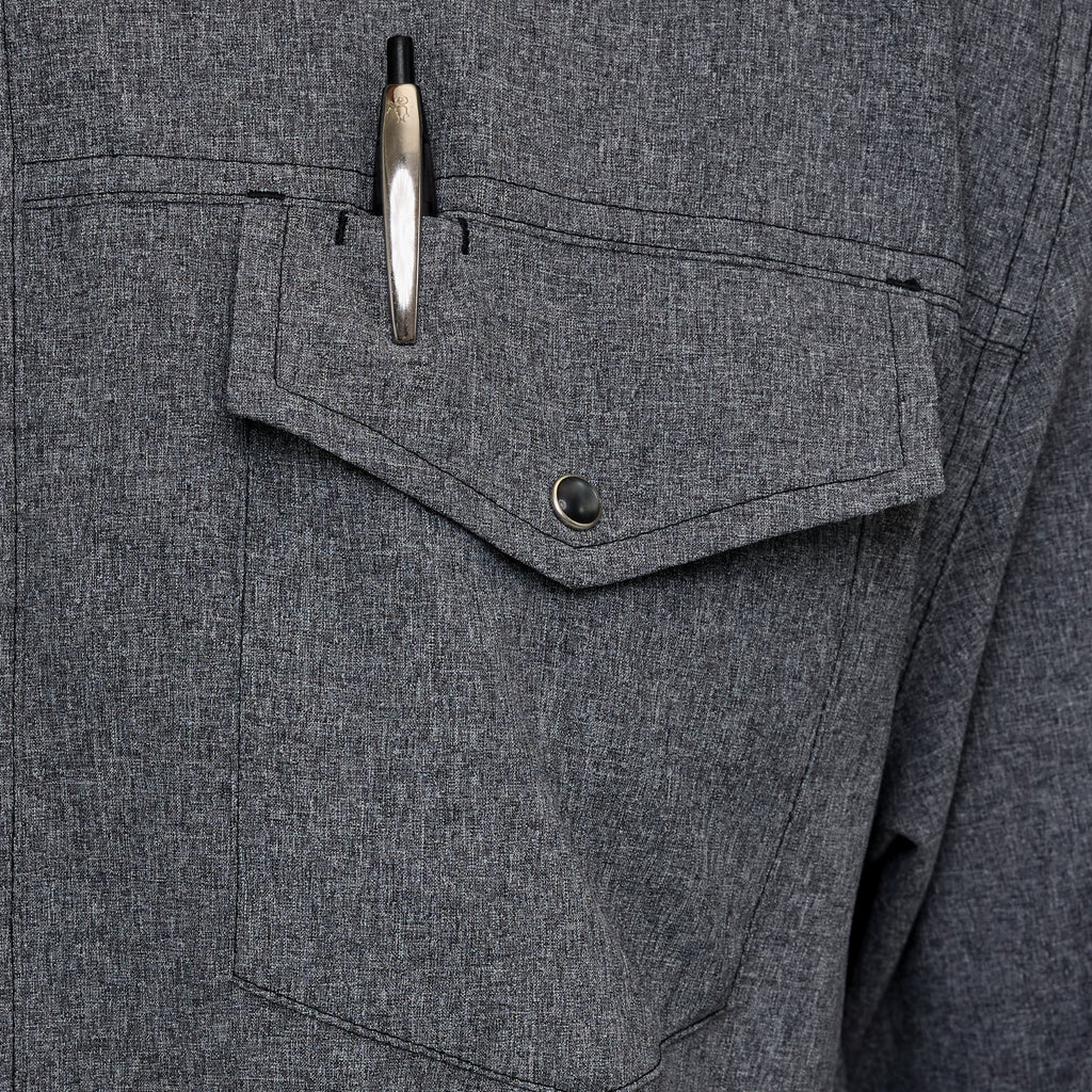 Dark gray shirt chest pocket with snap-button flap and metal buttons