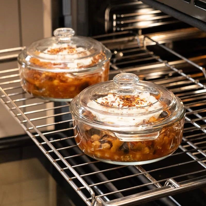 Glass Dutch oven with lid on oven rack, filled with baked dish