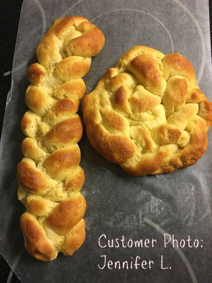 Gluten-free flour braided bread wreath on parchment with golden browned crust