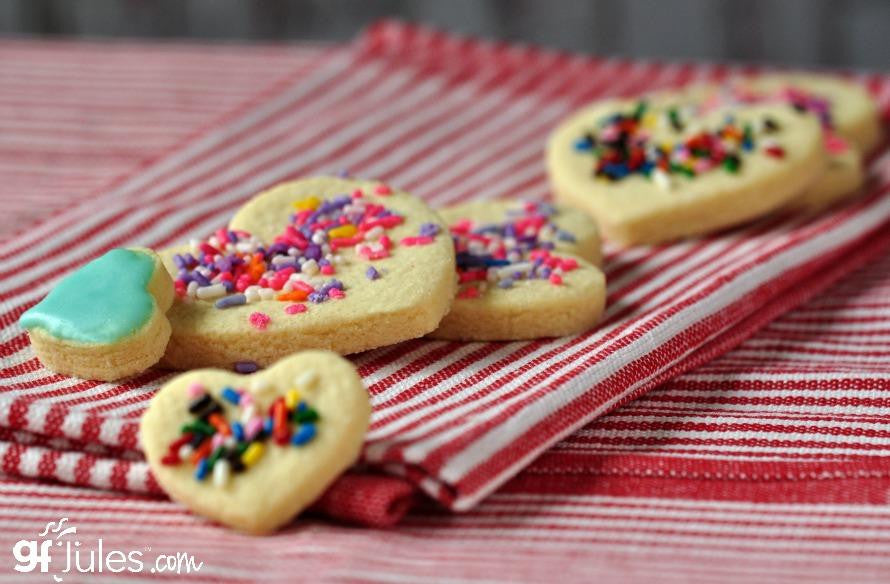 Gluten-free flour iced sugar cookies with colorful sprinkles on red-striped cloth