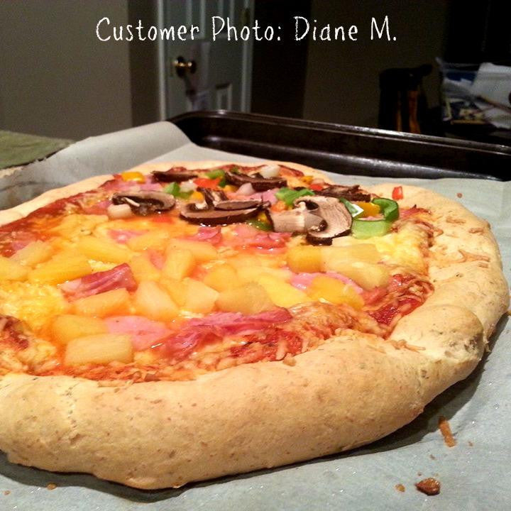 Gluten-free pizza crust mix, baked pizza in pan with cheese and colorful toppings