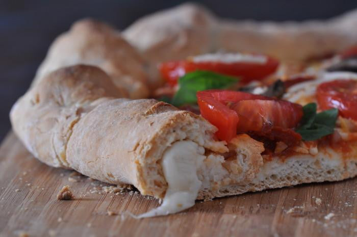Gluten-free pizza crust pieces with tomato, cheese, and basil topping