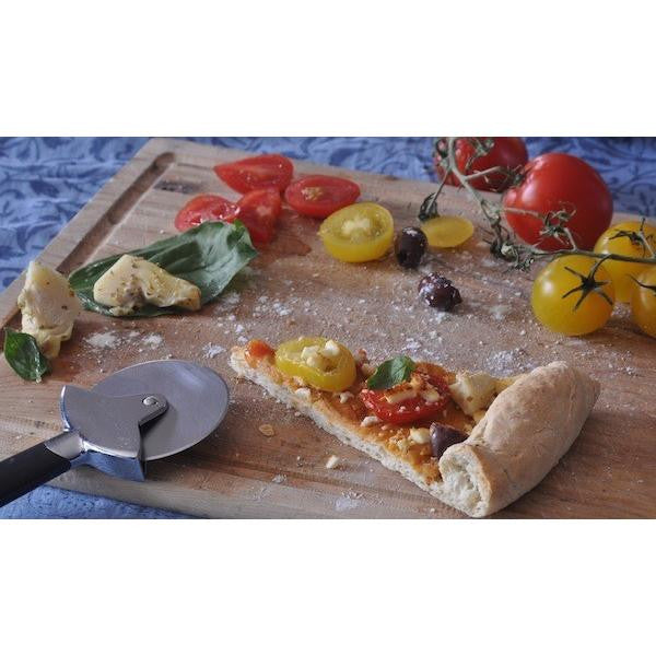 Unbaked gluten-free pizza dough sheet with chopped vegetables and herbs