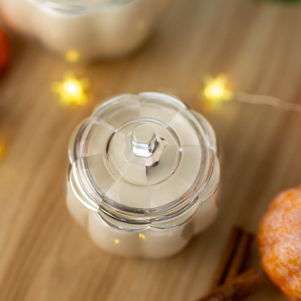 Close-up of clear glass candle jar lid knob with cream wax below