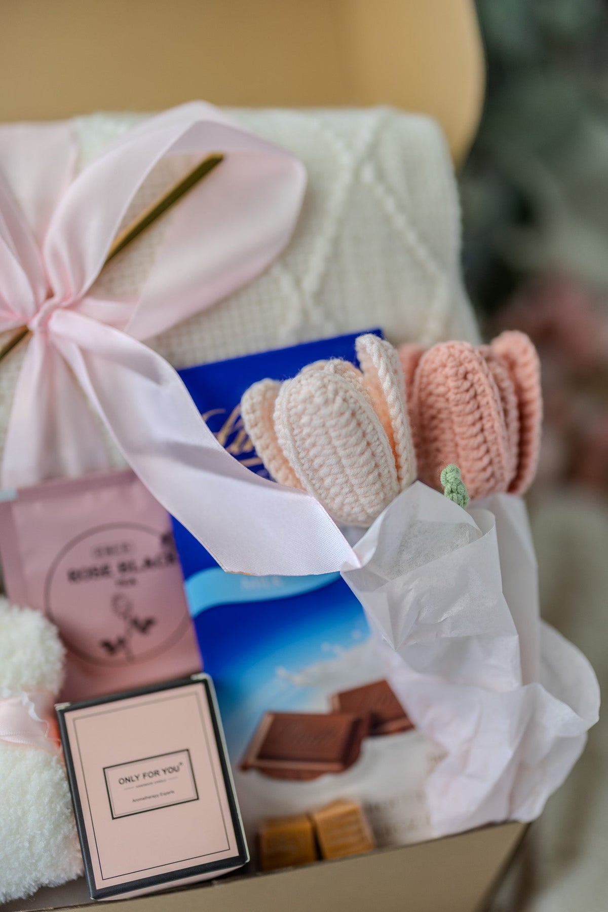 Pink gift care package with bath towels, ribbon bow, and assorted skincare bars