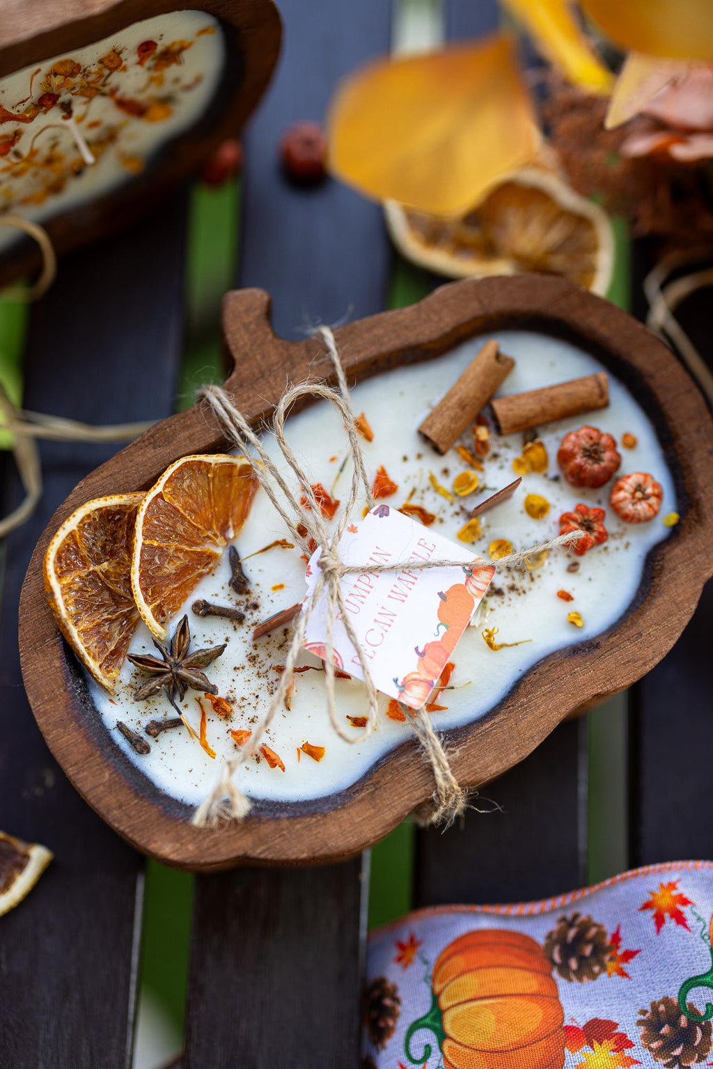 Wooden pumpkin-shaped dough bowl candle with white wax, cinnamon sticks, and twine