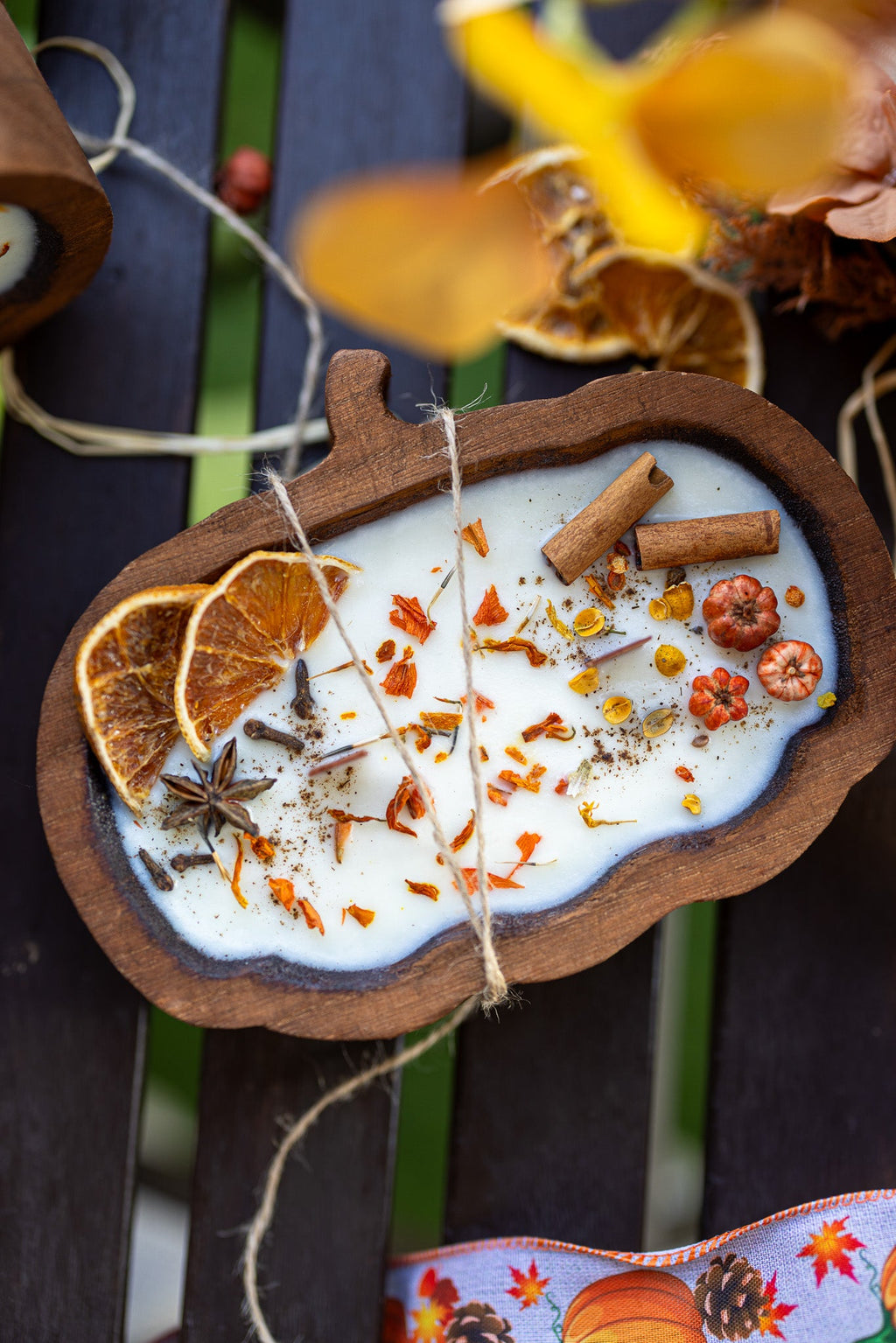 Wooden pumpkin dough bowl candle with cinnamon sticks, star anise, and orange slices