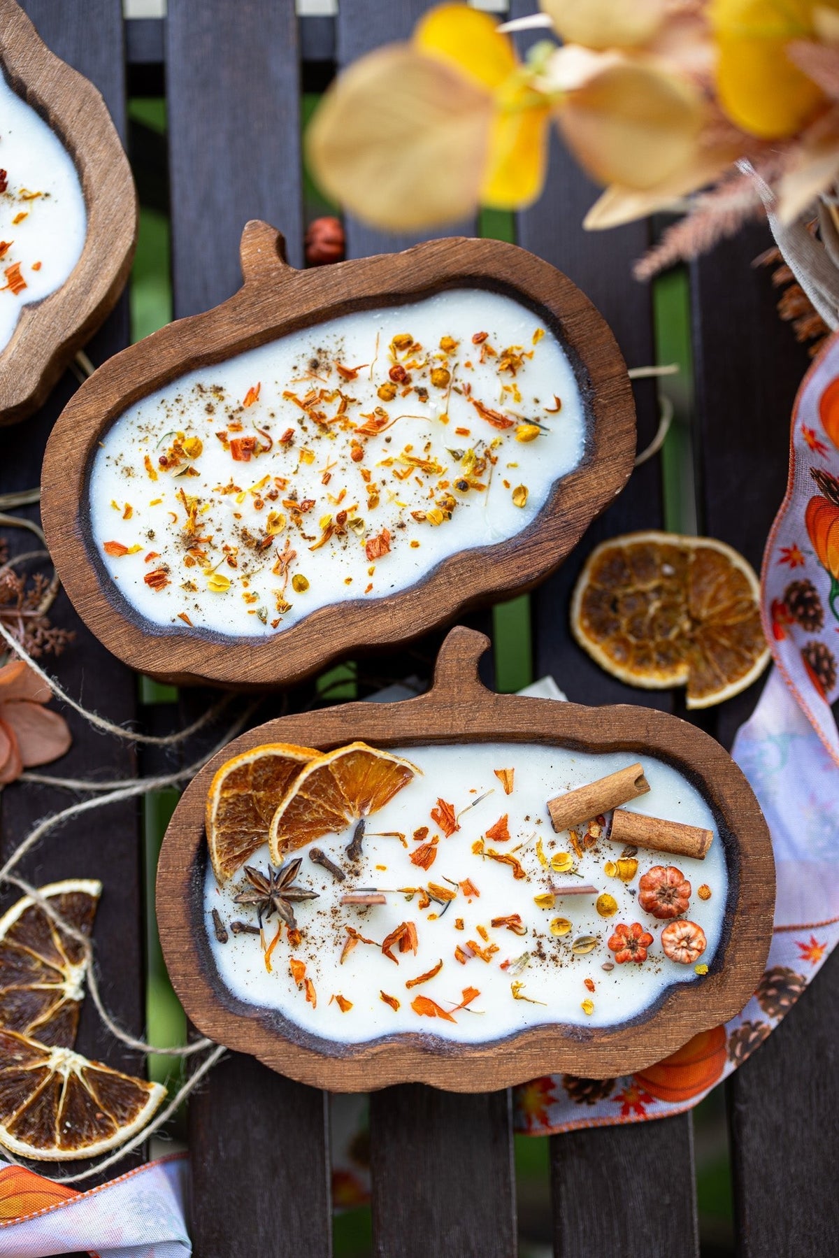 Pumpkin-shaped wooden dough bowl candle with white wax and scattered spice pieces