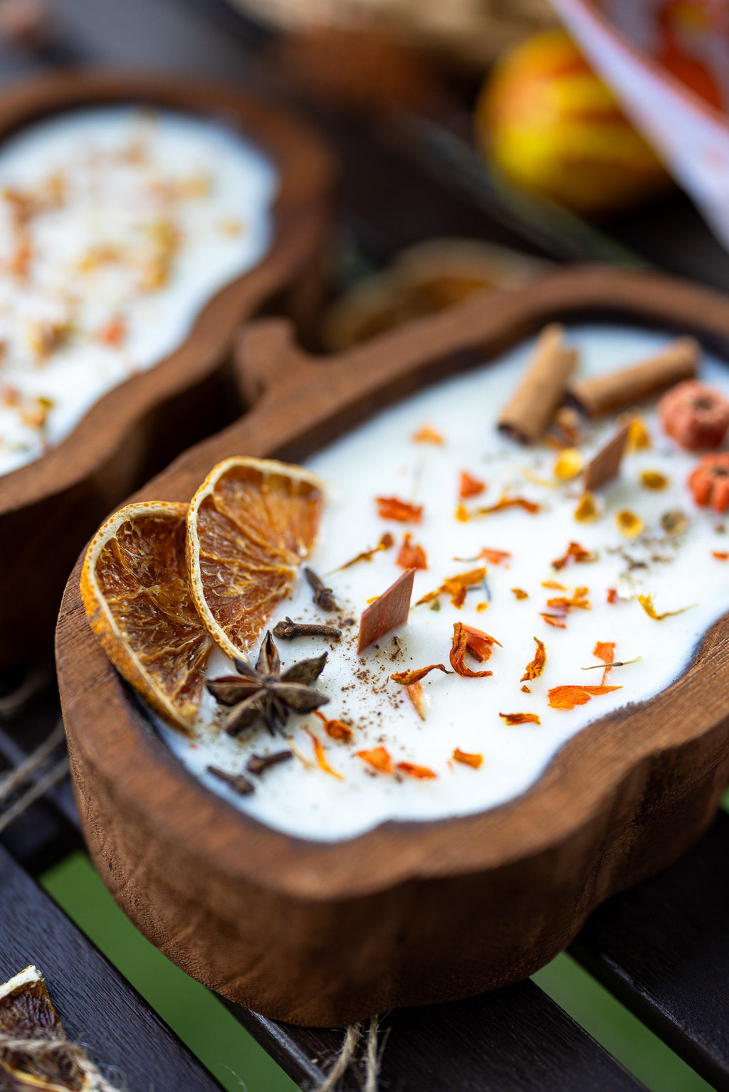 Close-up of wooden pumpkin-shaped dough bowl candle with white wax and cinnamon sticks