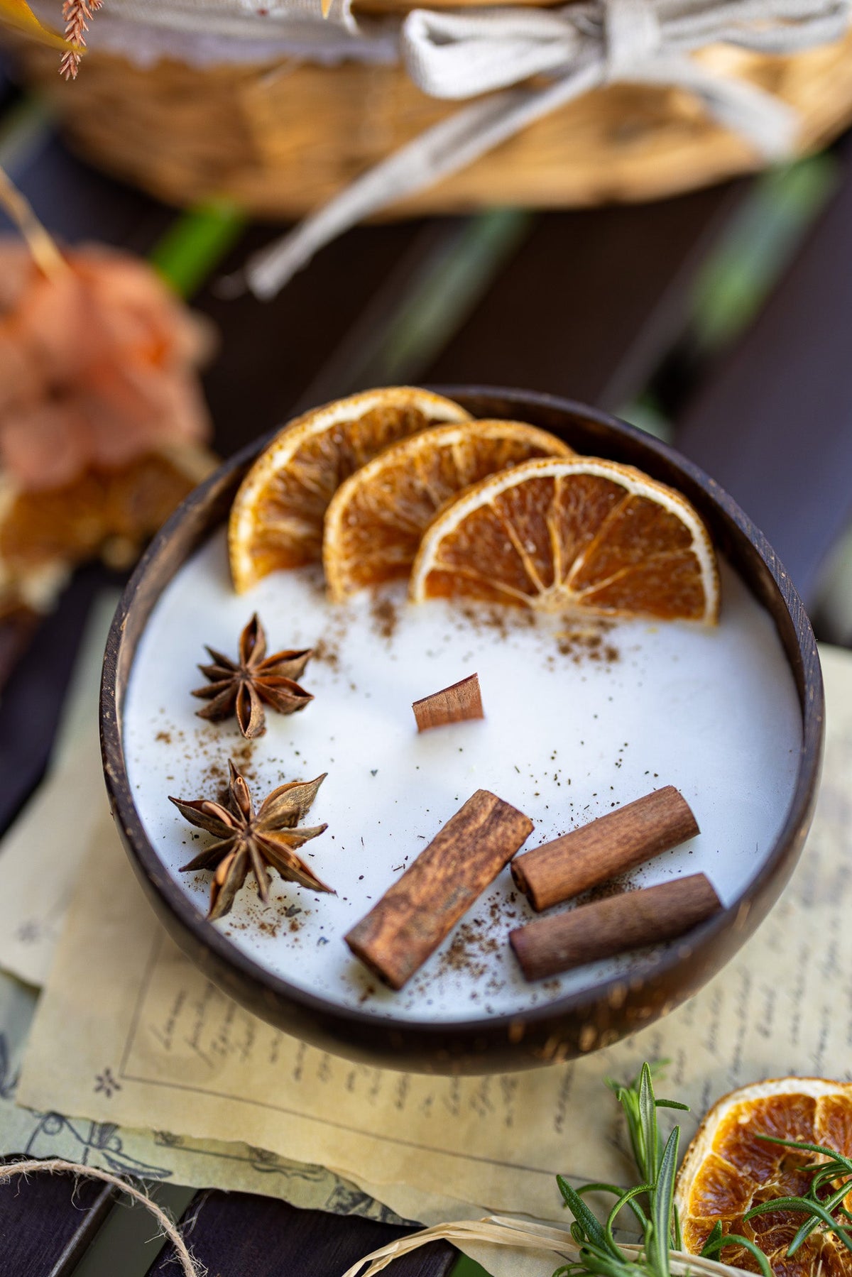 Scented candle bowl with white wax, orange slices, cinnamon sticks, and star anise garnish