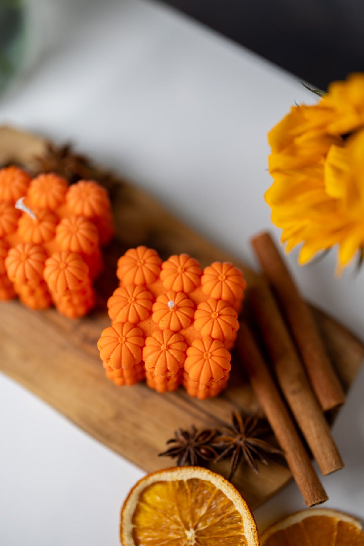 Orange pumpkin face bubble soy candle hearts with cinnamon sticks, star anise, and citrus