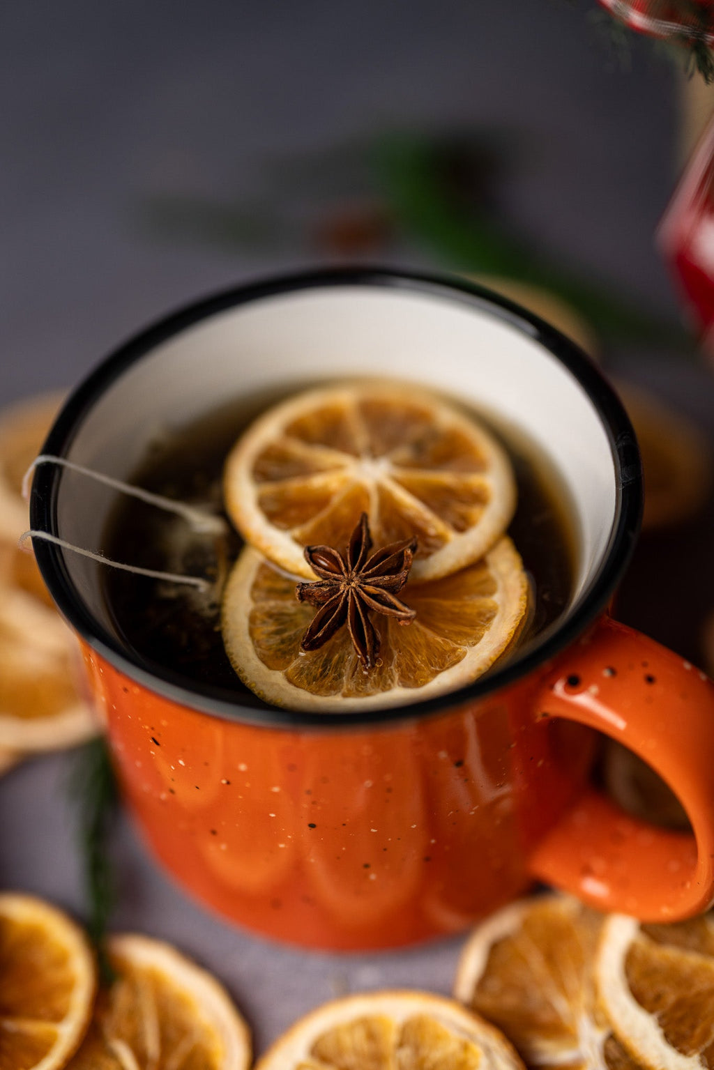 Hot spiced stovetop potpourri in orange mug with citrus slice and star anise