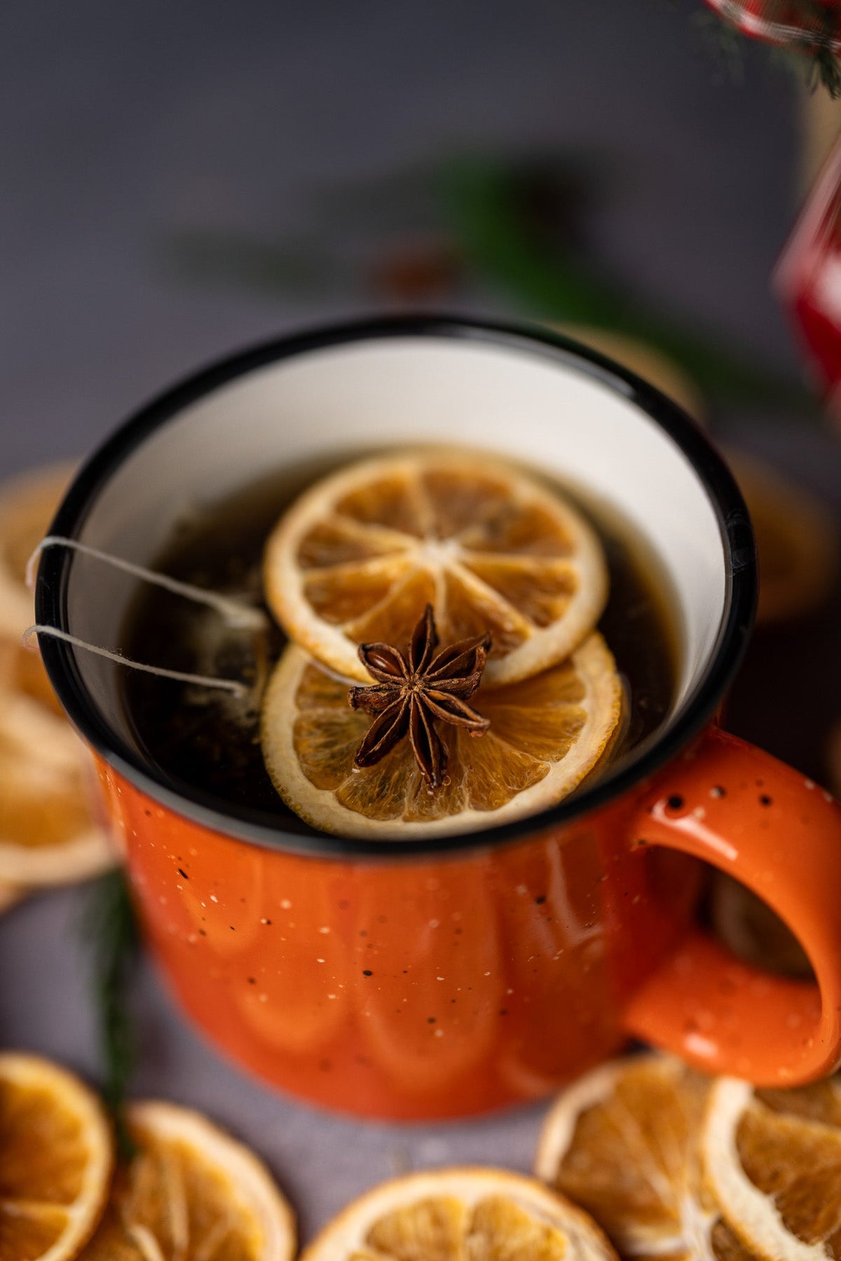 Hot spiced stovetop potpourri in orange mug with citrus slice and star anise