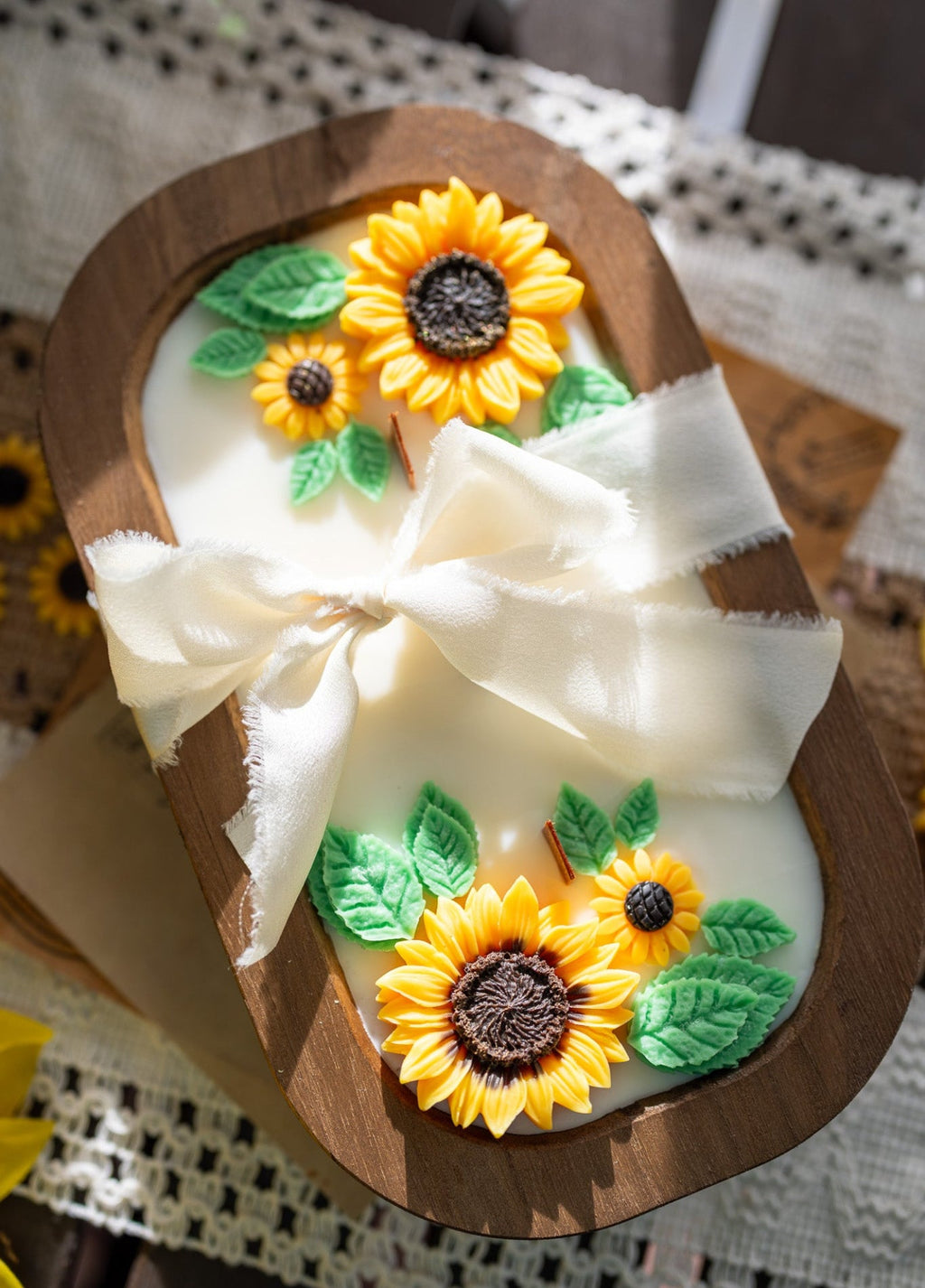 Wooden sunflower soy wax candle in oval holder with yellow blooms, green leaves, white ribbon bow