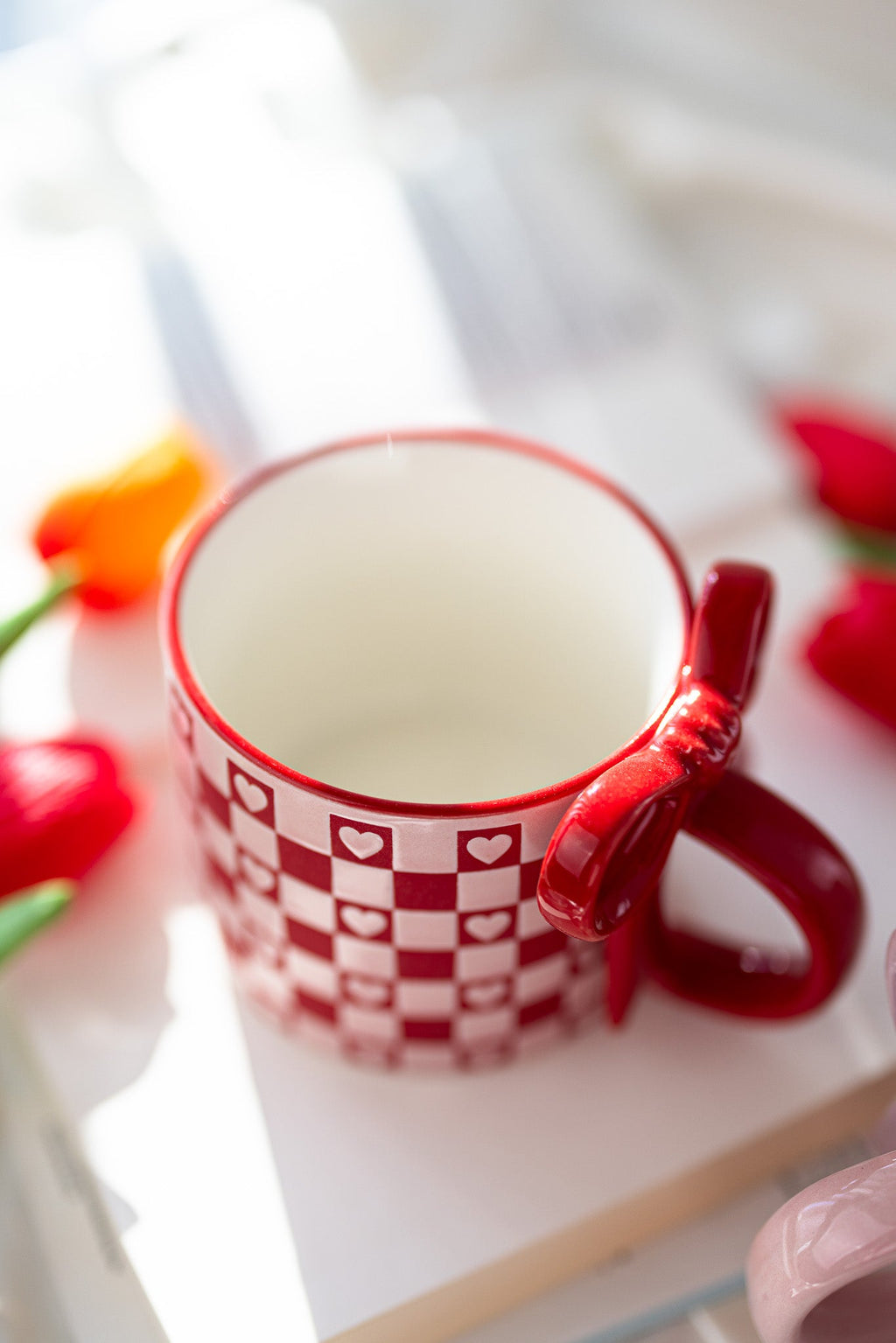Ceramic mug with red checkerboard hearts pattern and small heart accents on rim