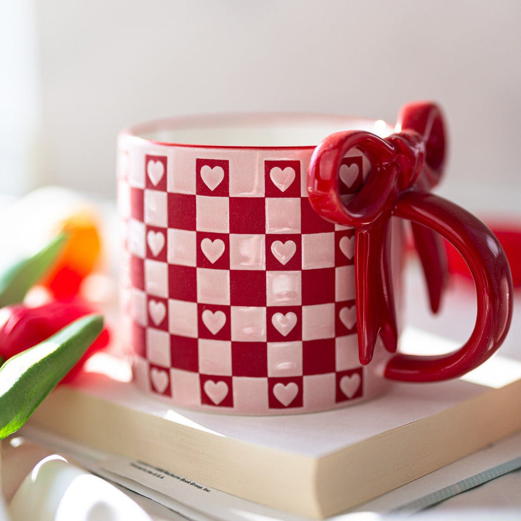 Ceramic mug in red and white with checkerboard hearts and glossy bowknot handle