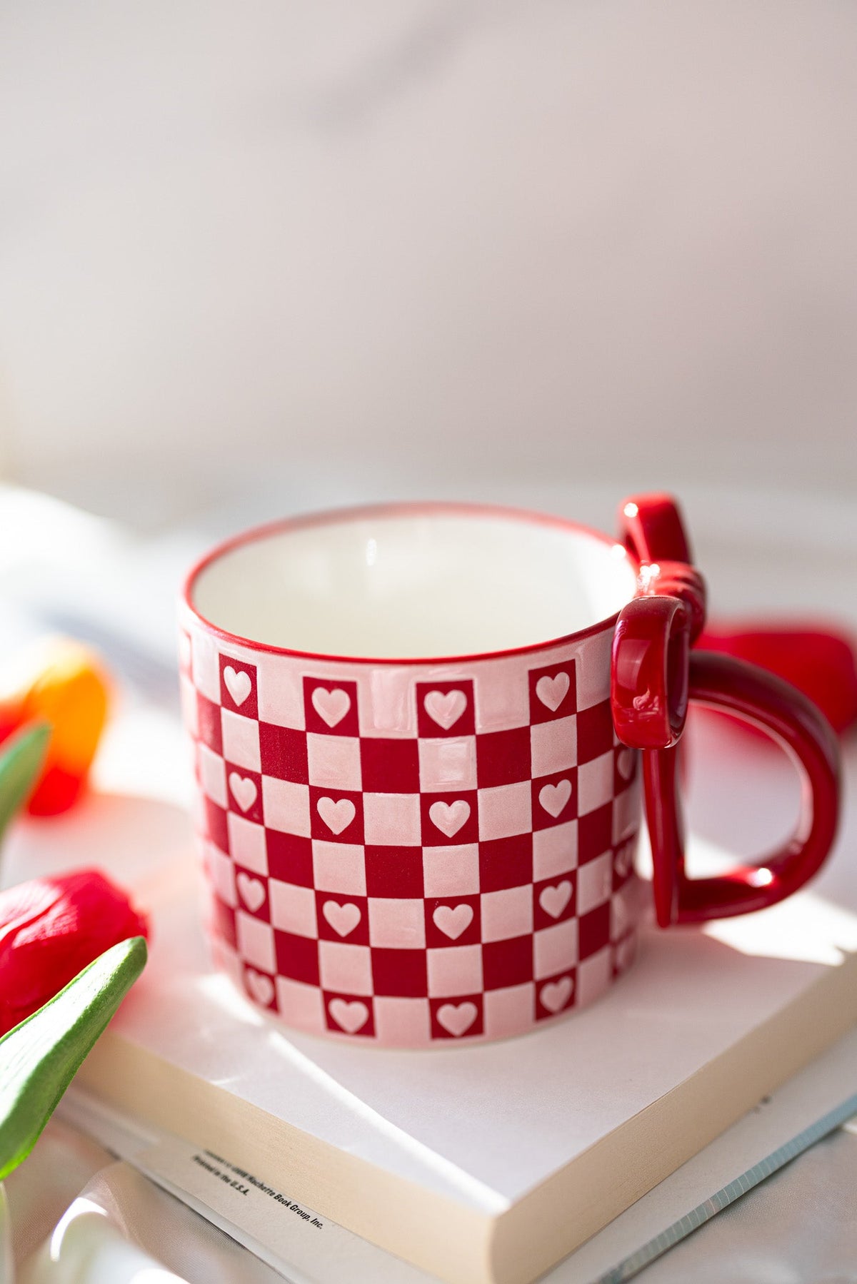 Ceramic mug in red and white with checkerboard hearts pattern and curved side handle