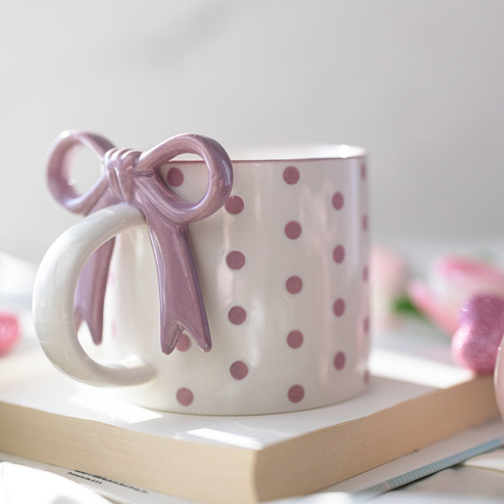 Pink and white ceramic mug with bowknot heart detail and polka-dot pattern
