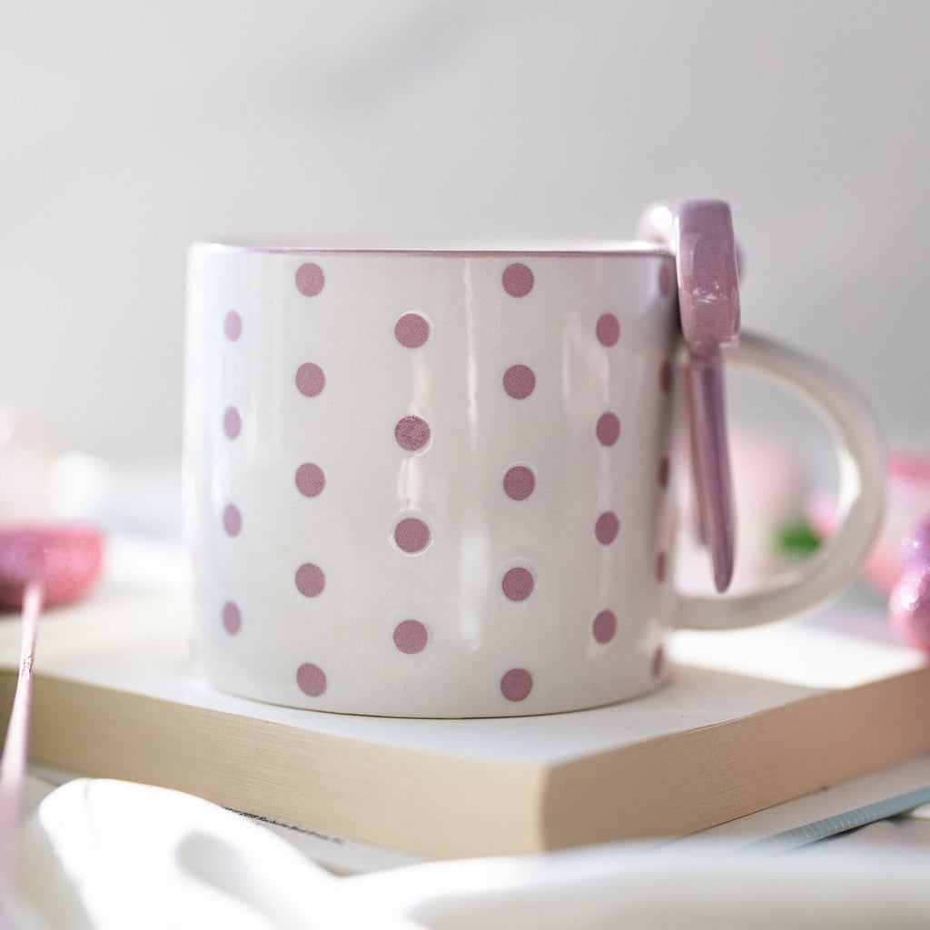 White ceramic mug with pink polka dots and bowknot handle ornament