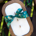 Wood dough bowl candle with white wax and teal holiday ribbon bow, exposed wicks